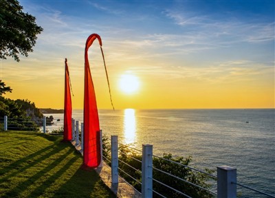 Red flags framing sunset at Uluwatu, Bali, Indonesia